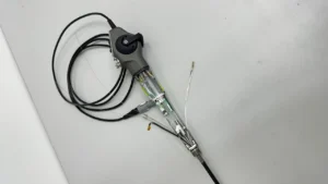 Endoscópio flexível em processo de reparo técnico, com chicote e cabos internos expostos para manutenção de deflexão, imagem e vedação